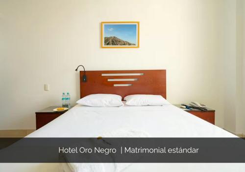 a bedroom with a large bed with a wooden headboard at Hotel Oro Negro in Talara