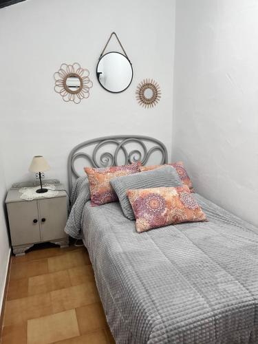 a bedroom with a bed with a lamp and pillows at Casa Rural Eufemia in Arenales de San Gregorio