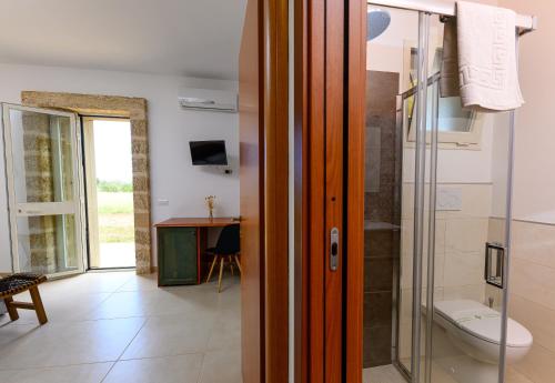 a bathroom with a toilet and a glass shower at Agriturismo Tenuta Calitre in Melendugno