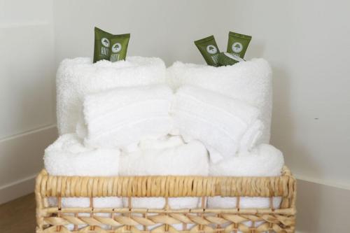 a basket filled with white towels and money at Excellence by Urooms Apartments Near NYC and Newark Airport with Parking in Elizabeth
