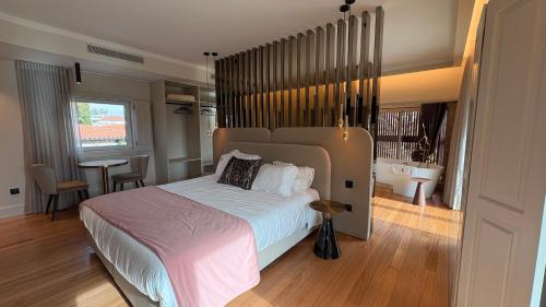 a bedroom with a large bed and a bathroom at Quinta Solar das Fontes in Várzea