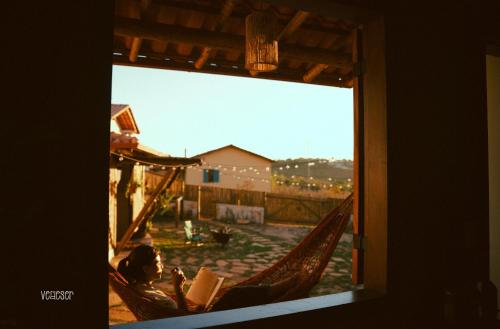 a person sitting in a hammock looking out a window at Chalés VerdeSer in Sêrro