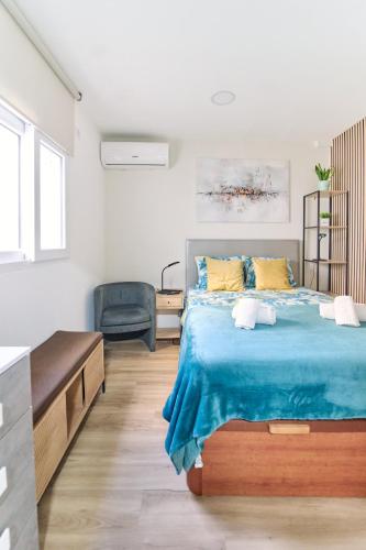 a bedroom with a bed with a blue blanket at Refúgio do Pilar in Vila Nova de Gaia