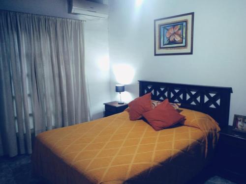 a bedroom with a bed with red pillows on it at La finca in San Rafael