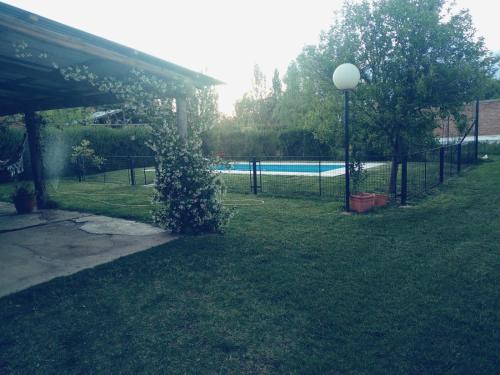 a garden with a fence and a swimming pool at La finca in San Rafael