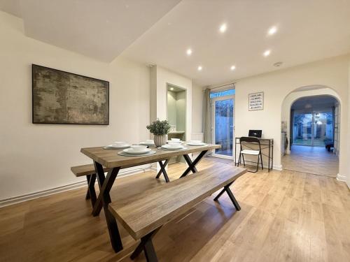 a dining room with a wooden table and a bench at 2 bed house secure parking Sleeps 6 in Ipswich