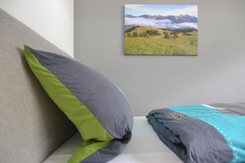 a pillow on a bed with a picture on the wall at Wohnen bei Gerlis in Burbach