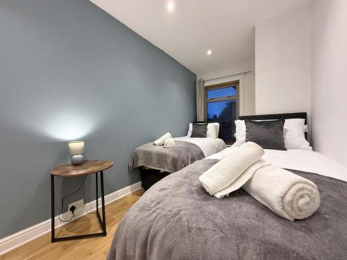 a bedroom with two beds and a window at 2 bed house secure parking Sleeps 6 in Ipswich