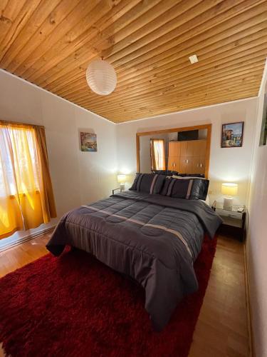a bedroom with a large bed with a wooden ceiling at Hostal Mar De Bahía in Bahia Inglesa