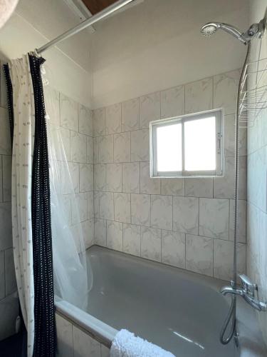a bathroom with a tub and a window at Hostal Mar De Bahía in Bahia Inglesa