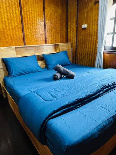 a large blue bed with a black object on it at Ploy Chumpoo Kantiang in Ko Lanta