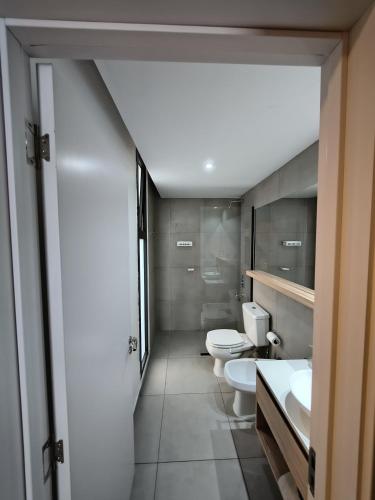 a bathroom with three toilets and two sinks at Canela Loft Rosario in Rosario