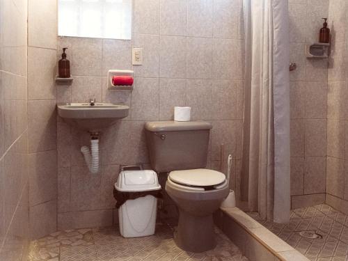 a bathroom with a toilet and a sink at Casa Porta Rosa in Brisas de Zicatela