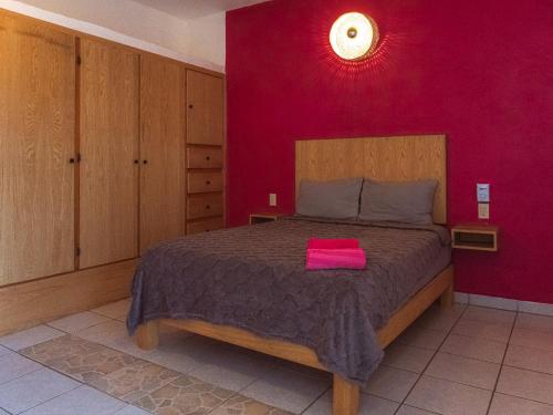 a bedroom with a bed with a pink towel on it at Casa Porta Rosa in Brisas de Zicatela