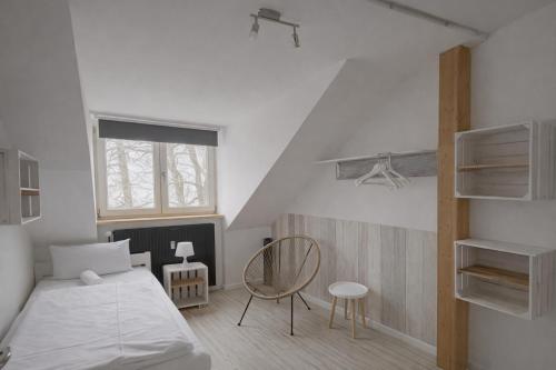 a small bedroom with a bed and a chair at Hamburg Sleep Club in Hamburg