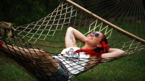 a woman with red hair laying in a hammock at Munroe Eco Camp in Munroe Island
