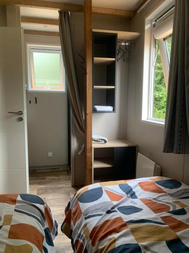 a bedroom with a bed and a window and a door at Les cottages du Tremble in Ruffec
