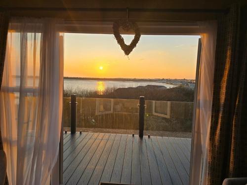 a window with a heart hanging from it with the sunset at 1 Sunset View in Millom