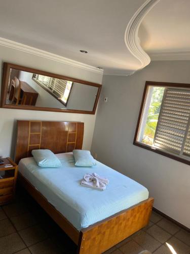 a bedroom with a bed and two windows at Garden Hotel in Nova Era