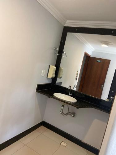 a bathroom with a sink and a mirror at Garden Hotel in Nova Era