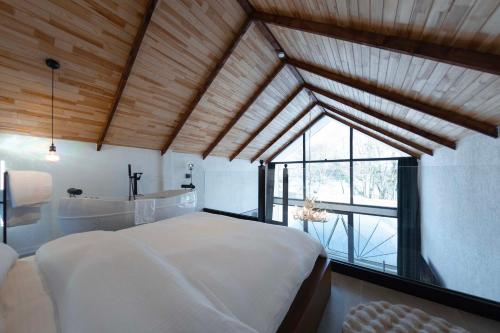 a bedroom with a large white bed and a tub at Rubis Villa Bungalov in Elmalık