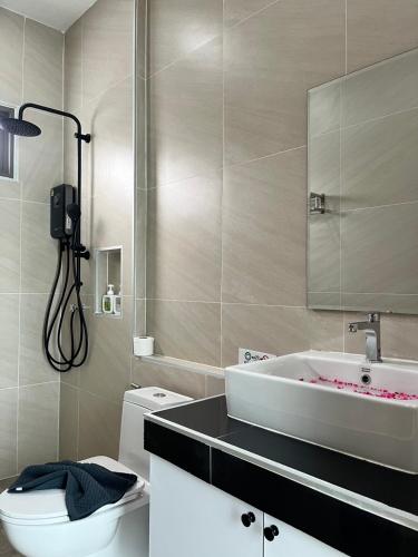 a bathroom with a white toilet and a sink at Legacy pool villa in Ban Chong Phli