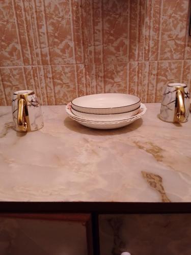 a plate sitting on top of a table next to two cups at Venguest Homes & Accomodation in Naivasha
