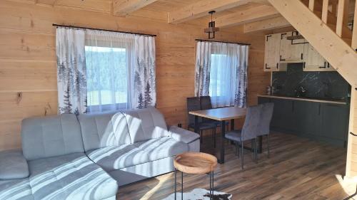 a living room with a couch and a table at Góralska Przystań in Nowa Wieś