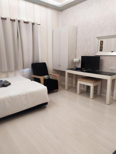 a bedroom with a bed and a desk with a computer at pinsker apartment city center in Petaẖ Tiqwa