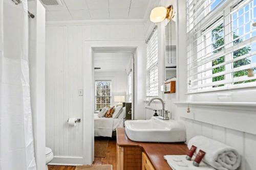 a white bathroom with a sink and a mirror at Beaufort 308 Charles in Beaufort