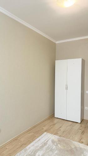 pusty pokój z białą szafką i drewnianą podłogą w obiekcie ИП.МЕДИНА w mieście Taraz