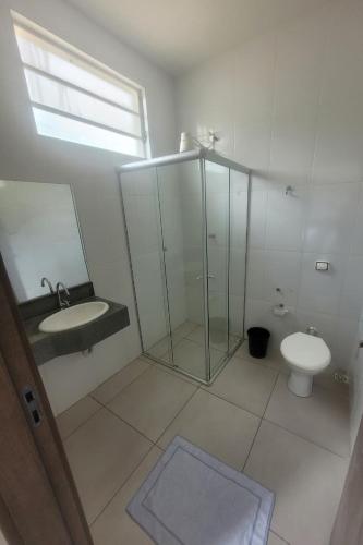 a bathroom with a shower and a sink and a toilet at Hotel Master Plaza Formiga in Formiga