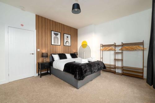 a bedroom with a bed and a wooden wall at Monks Quarters, Luxury 3 bed, Sleeps 6, PRIVATE PARKING x 2, Ideal for Groups & families, Prime location in Lincoln