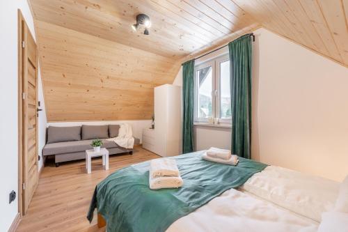 a bedroom with a bed and a couch in a room at Domek Wierzbowa 5 in Brenna