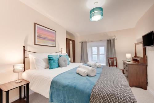 a bedroom with a large bed with blue and white pillows at 3 Bed in Machynlleth oc-bow306 in Darowen