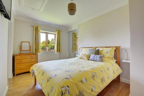 a bedroom with a bed and a dresser and a window at 2 Bed in Ingworth oc-1731 in Ingworth