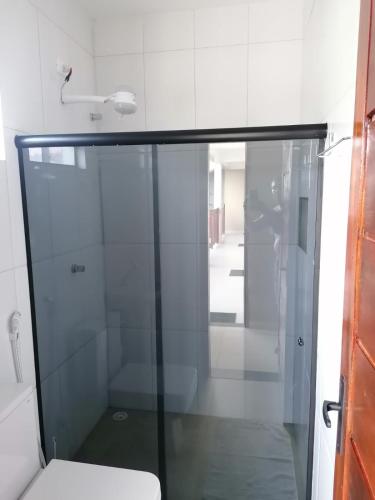 a bathroom with a glass shower and a toilet at Pousada Tropical dos Corais in Cabo de Santo Agostinho