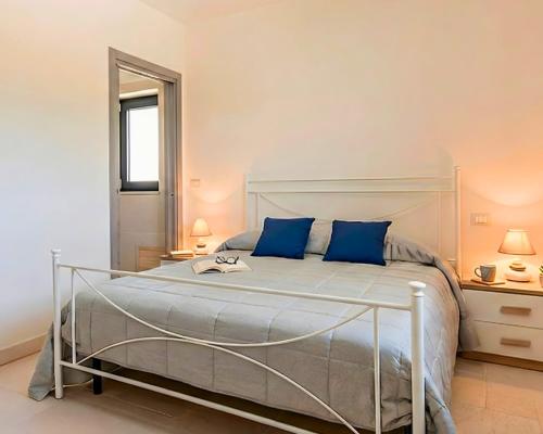 a bedroom with a large bed with blue pillows at Stefano's Villa in Cisternino