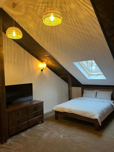 a bedroom with a bed and a flat screen tv at Къща за гости Геша Форест 3 in Dryanovo