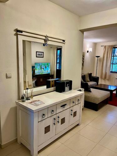a living room with a large mirror and a living room with a television at Къща за гости Геша Форест 3 in Dryanovo