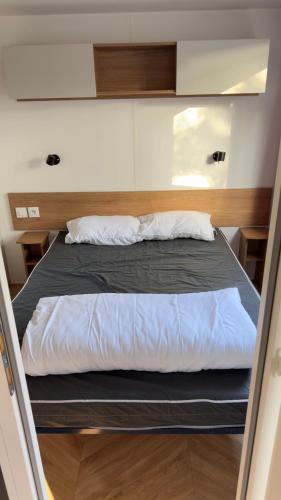 a bed in the middle of a small room at Mobil home 148 in Pont-Aven