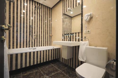 a bathroom with a sink and a toilet and a tub at Sevan Up In in Aghk'ilisa