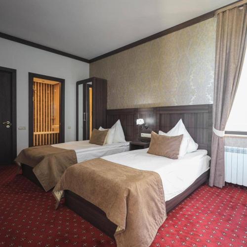 a hotel room with two beds and a window at Sevan Up In in Aghk'ilisa
