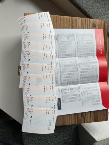 a stack of papers sitting on top of a book at Tirano stazioni flow rooms in Tirano