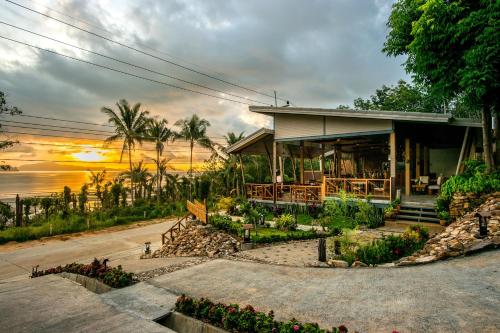 uma casa na praia com um pôr-do-sol ao fundo em Koh Yao Yai Hillside Resort em Ko Yao Yai