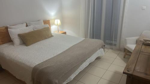 a bedroom with a bed and a chair and a window at Sol & Lar No stress in Santa Maria