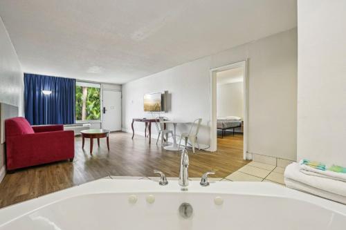 a room with a bath tub and a living room at Stayable Lakeland in Lakeland