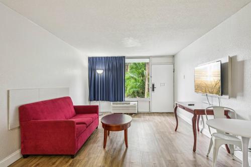 a living room with a red couch and a table at Stayable Lakeland in Lakeland