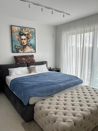 a bedroom with a large bed with a blue blanket at Villa Oasis Poreč in Labinci