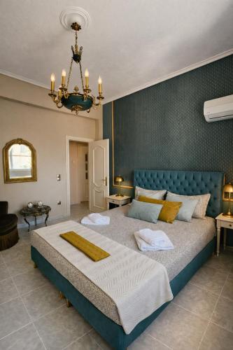 a bedroom with a large bed and a chandelier at Allegoria House in Nafplio